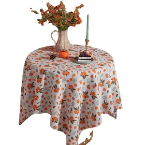 Nordic orange citrus print linen tablecloth on round table with afternoon tea set