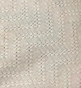 Macro shot of beige linen fabric featuring detailed herringbone weave texture and fibers