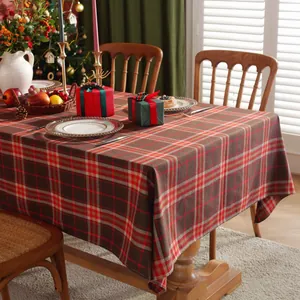 Nahaufnahme der klassisch rot-grün karierten Weihnachtstischdecke auf einem Holztisch