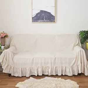 Nordic minimalist beige linen sofa cover with elegant ruffled edges in a cozy home setting