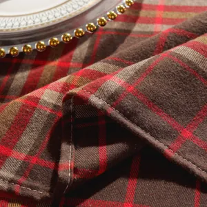 Nahaufnahme der rot karierten Tischdecke mit Baumwoll-Leinen-Textur und weißer Overlock-Naht