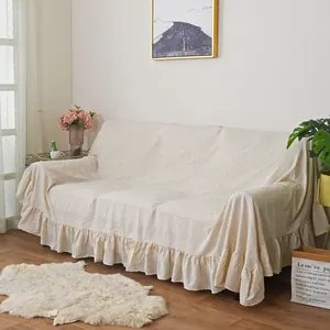 Detail of cream cotton sofa cover featuring elegant ruffled edges and premium linen texture