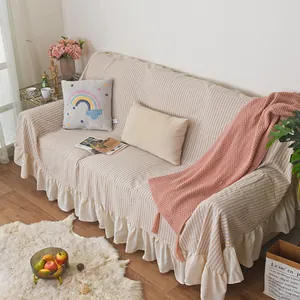Detailed ruffled hem and beige striped texture of a full-cover sofa slipcover