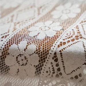 Close-up of beige hollow diamond lattice curtain fabric with floral lace texture