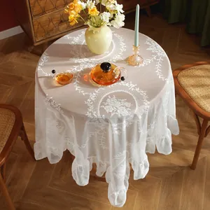Elegant white lace tablecloth with floral embroidery and ruffled edges for home decor
