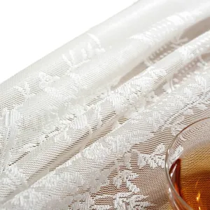 Elegant white floral lace tablecloth with ruffled edges and sheer jacquard fabric texture
