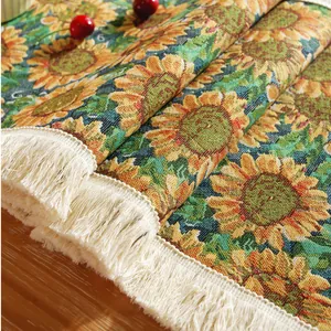 Detail of woven table runner with sunflower jacquard pattern and white fringe edge