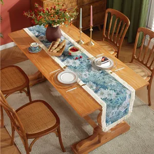 Detail of vintage blue jacquard table runner featuring floral patterns and white tassels