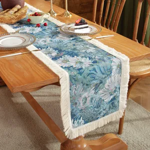 Detailed view of dark blue jacquard table runner with white floral patterns and tassels