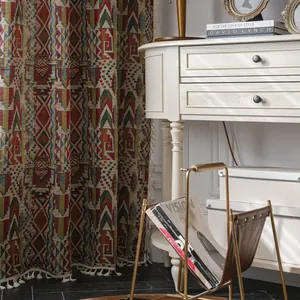 Bohemian geometric pattern curtains with cream tassels in a sunlit rustic bedroom setting