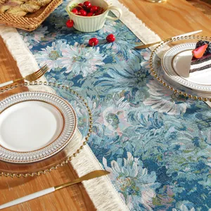 Detailed jacquard floral texture of the navy blue table runner with cream fringe