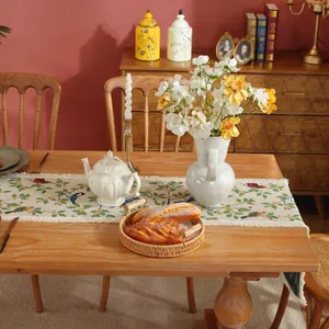 Dettaglio del runner da tavolo vintage jacquard con fiori, uccelli e nappe decorative