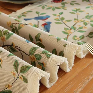 Dettaglio del runner da tavola jacquard con fiori e uccelli e nappe decorative