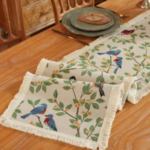Dettaglio del runner da tavola jacquard con motivi di uccelli e frange rustiche ai bordi