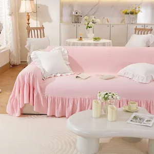 Detailed view of pink sofa cover with ruffled hem and minimalist textured fabric