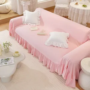 Detail of soft pink cotton sofa cover featuring elegant ruffled edges and premium texture