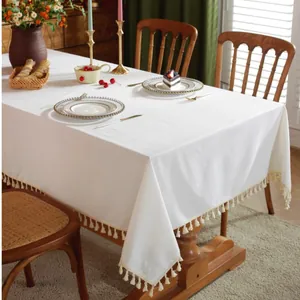 White rectangle tablecloth with tassel fringe on a wooden table with tea set