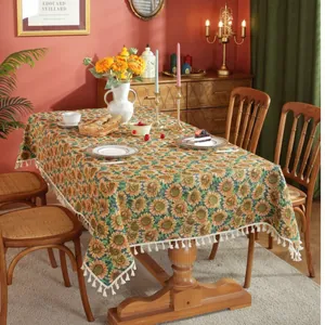 Retro zonnebloem tafelkleed met pompon franjes in een vintage landelijke eetkamer setting