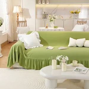 Close-up of light green cotton sofa cover with elegant ruffled edges and lace pillow detail