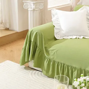 Detail of light green cotton sofa cover with elegant ruffle edges and matching pillow