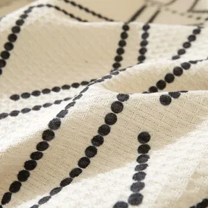 Detalle de la funda de sofá con textura de gofres en tela beige y patrones de puntos