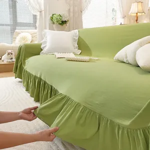 Detail of green linen sofa cover featuring elegant ruffled edges and durable texture