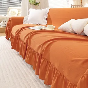 Detail view of caramel orange cotton sofa cover with elegant ruffled edge hem design