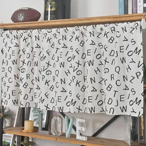 Modern white cafe curtain with black letter print hanging on a wooden shelf in a cozy room