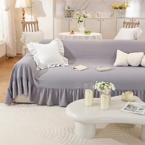 Close-up of lilac ruffled sofa cover with decorative bow pillows in a cozy home setting
