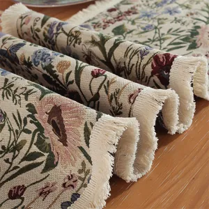 Dettaglio del runner da tavolo in jacquard floreale con nappe retrò su legno caldo