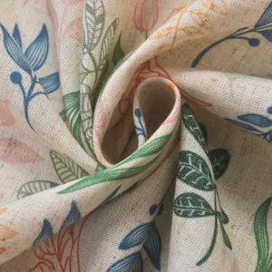 Close-up of linen fabric with colorful floral leaf patterns showing texture and drape