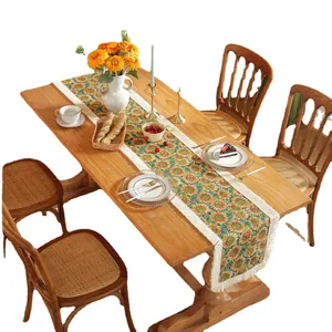 Retro sunflower jacquard table runner with white tassels on a rustic wooden table