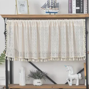 Detail of hollow lace cafe curtain with elegant diamond patterns and fringe tassels