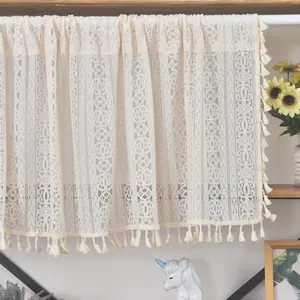 Macro view of beige lace short curtain featuring hollow patterns and tassel fringe details