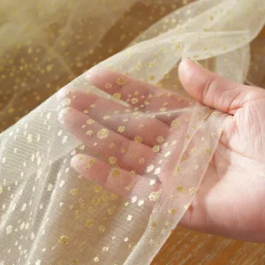 Detailopname van beige tule stof met gouden stippen voor transparantie en textuur