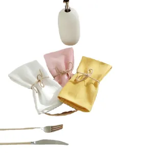 Drie katoenen placemats in wit roze en geel met touw op een eettafel gedecoreerd