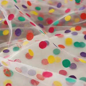 Detailopname van witte doorschijnende mesh tafelloper met kleurrijke glitterstippen