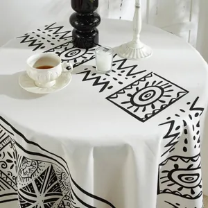 Bohemian round tablecloth featuring black Moroccan geometric patterns on white cotton linen fabric