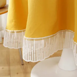Yellow round tablecloth with white lace edges and cotton linen texture for home weddings