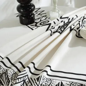 Close-up of geometric black print on round thick linen tablecloth with home decor