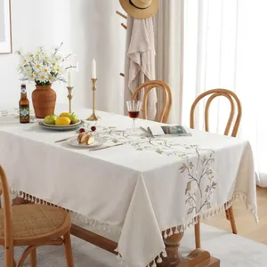Detail of cream rectangle tablecloth with leaf embroidery and decorative fringes
