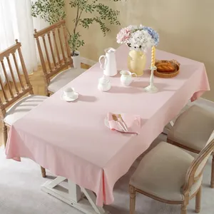 Detail shot of light pink cotton linen tablecloth draped with elegant home dining decor