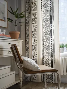 Detail of bohemian cotton linen curtain with black geometric patterns in a cozy room