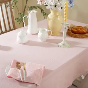 Pink solid cotton tablecloth and napkins with natural crinkle texture on dining table
