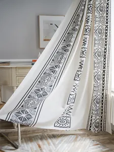 Detail of bohemian cotton linen curtain featuring black geometric patterns on white fabric