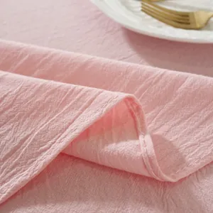 Detail of soft pink cotton tablecloth with stitched edges, elegant dining table setting