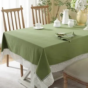 Detail van het grasgroene katoen-linnen tafelkleed met een elegante witte kanten rand