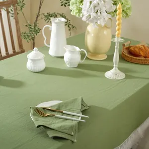 Detailopname van het saliegroene linnen tafelkleed met witte franjes en bijpassende servetten