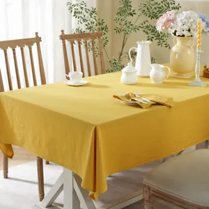 Close-up of ginger yellow cotton tablecloth with natural wrinkled texture and matching napkin