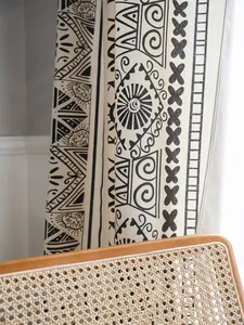 Detail of bohemian black geometric print on off-white cotton linen curtains with chair